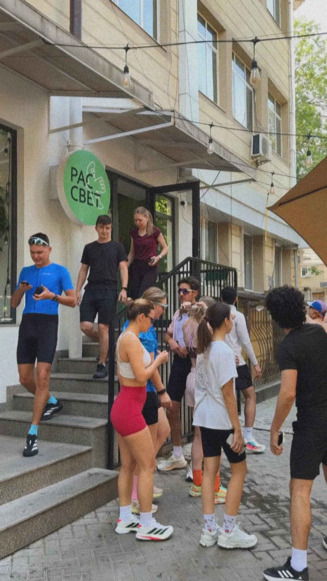 Бегуны отдыхают на ступеньках кофейни после Social Run